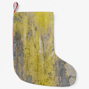 Old gray concrete wall with peeling yellow paint. small christmas stocking