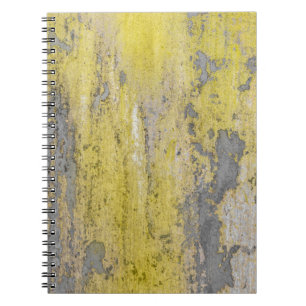 Old grey concrete wall with peeling yellow paint.  notebook