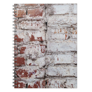 Old painted brick wall with peeling white paintwal notebook