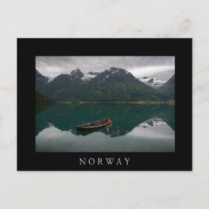 Old rowboat and mountains in Norway black postcard