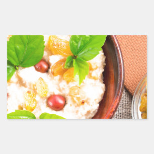 Old wooden bowl of healthy oatmeal with berries rectangular sticker
