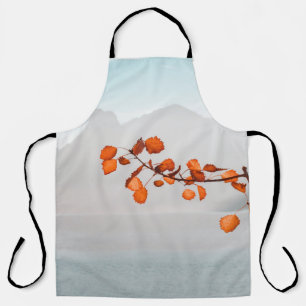 ORANGE LEAF NEAR BODY OF WATER AND MOUNTAINS APRON