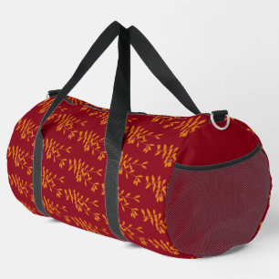 Orange silhouette branch leaves on red duffle bag