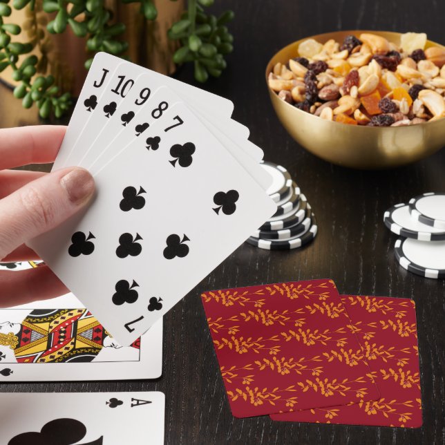 Orange silhouette branch leaves on red playing cards (In Situ)