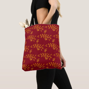 Orange silhouette branch leaves on red tote bag