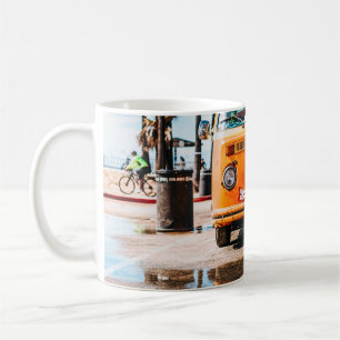Orange van with surfboard on top coffee mug