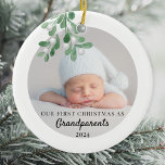 Our First Christmas As Grandparents Foliage Photo  Ceramic Ornament<br><div class="desc">This Grandparent's First Christmas Ornament is decorated with green watercolor mistletoe. Easily customisable with your baby's photo, name, and year. Use the Design Tool to change the text size, style, or colour. Because we create our artwork you won't find this exact image from other designers. Original Watercolor © Michele Davies....</div>