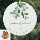 Our First Christmas Engaged Green Mistletoe Photo Ceramic Ornament<br><div class="desc">Celebrate your first Christmas as an engaged couple with this stylish photo ceramic ornament. 
It is decorated with watercolor mistletoe and elegant green script typography.
Easily customisable with your names,  date,  and photo.
Use the Design Tool to change the text size,  style,  or colour.
Original Watercolor © Michele Davies.</div>