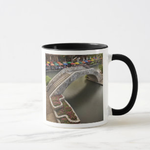 Outdoor cafe along River Walk and bridge over Mug