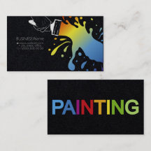 Paintbrush with blots of coloured paint in the han