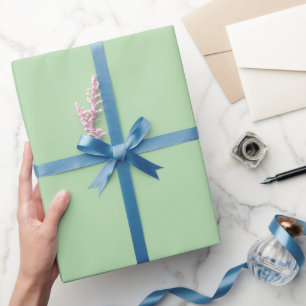 pale sage-green wallpaper sheet, partly rolled wrapping paper