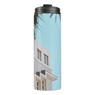 Palm tree near white concrete building thermal tumbler