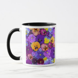 Pansy flowers floating in bird bath with dew mug
