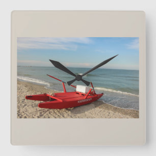 Pattino rosso sulla spiaggia - ricordi di mare square wall clock
