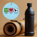 Peace Love Pilates Ceramic Ornament<br><div class="desc">Peace Love Pilates. A cute pilates instructor gift featuring a peace sign,  heart,  and woman stretching over an exercise ball.</div>