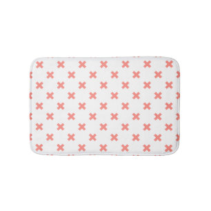 Peach cross stitches on white bath mat