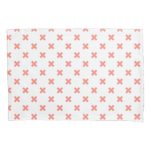 Peach cross stitches on white pillowcase