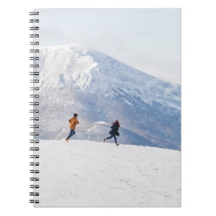 People having fun and running in mountains on the notebook