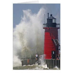 People on jetty watch large breaking waves in
