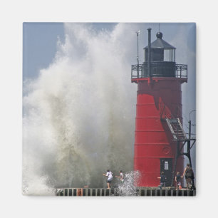 People on jetty watch large breaking waves in magnet