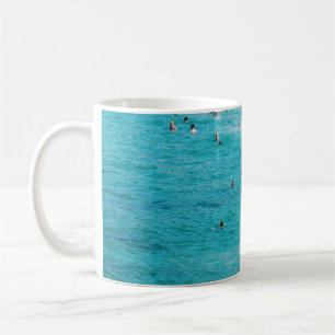 People swimming in the beach coffee mug