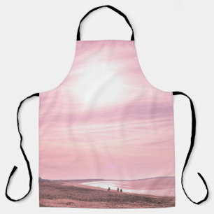 PEOPLE WALKING ALONG SEASHORE DURING GOLDEN HOUR APRON