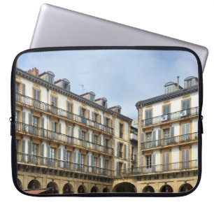 PEOPLE WALKING NEAR BEIGE CONCRETE BUILDING DURING LAPTOP SLEEVE