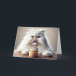 Persian Cat Licking a Birthday Cupcake Card<br><div class="desc">A fluffy white Persian cat is playfully licking its nose while sitting in front of a cupcake adorned with colourful sprinkles and a single lit candle
The inside text can be changed.</div>