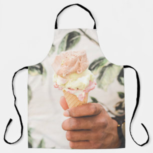 Person holding ice cream cone with three flavours apron