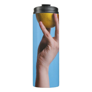 Person holding lemon thermal tumbler