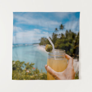 Person holding mason jar with filled with juice at tapestry