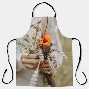 PERSON HOLDING ORANGE PEALED FLOWER APRON