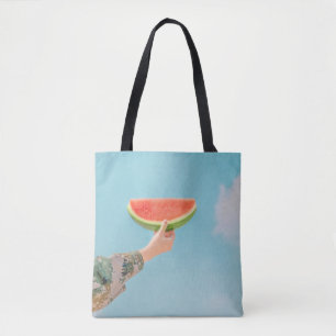 Person holding sliced watermelon tote bag