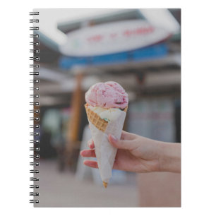 Person holding strawberry ice cream notebook