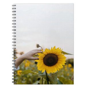 Person holding sunflower notebook