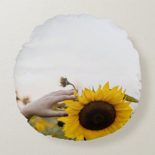 Person holding sunflower round cushion
