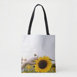 Person holding sunflower tote bag