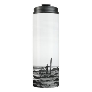 PERSON HOLDING SURFBOARD NEAR BODY OF WATER THERMAL TUMBLER