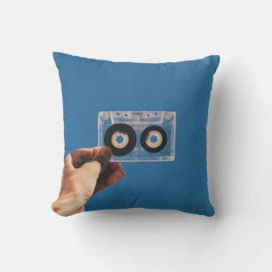 Person holding white and black cassette tape cushion