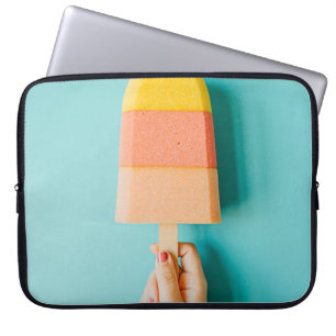 Person holding yellow and brown ice cream cone laptop sleeve