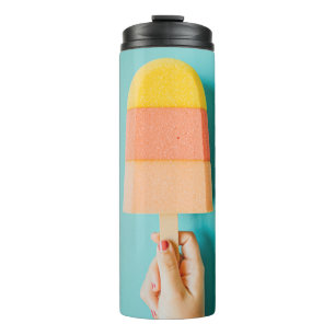 Person holding yellow and brown ice cream cone thermal tumbler