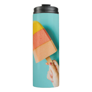 Person holding yellow and pink popsicle thermal tumbler