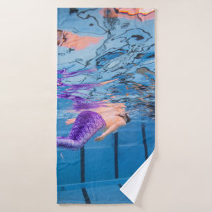 Person in purple pants lying on blue hammock bath towel