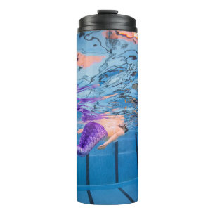 Person in purple pants lying on blue hammock thermal tumbler