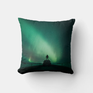 PERSON STANDING IN FRONT OF AURORA LIGHTS CUSHION