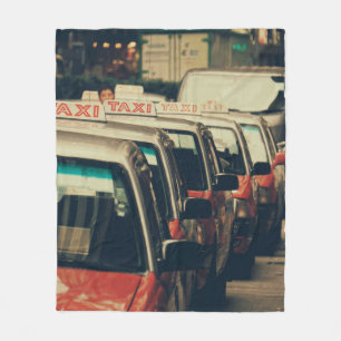 PERSON STANDING NEAR PARKED TAXI DURING DAYTIME FLEECE BLANKET