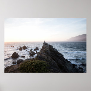 PERSON STANDING ON ROCK CLIFF NEAR BODY OF WATER POSTER