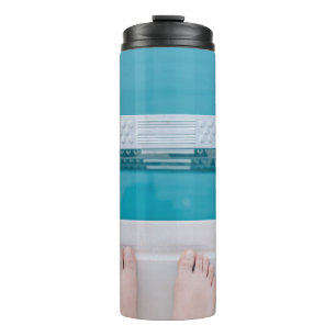 Person standing on swimming pool ladder thermal tumbler