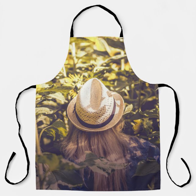 Person wearing white hat beside sunflower fields apron (Front)