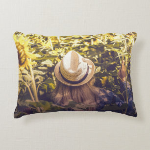 Person wearing white hat beside sunflower fields decorative cushion